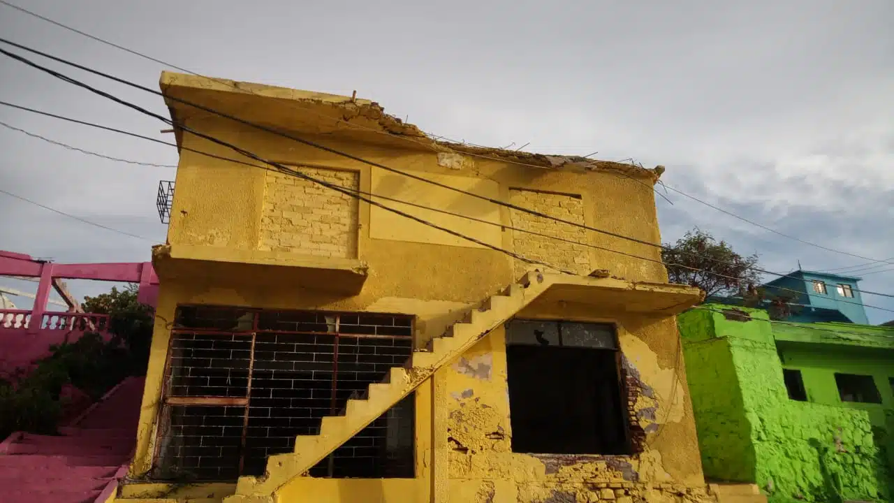 Casa de dis plantas, color amarillo, abandonada en Toolobampo con un pezado de la marquesina caído