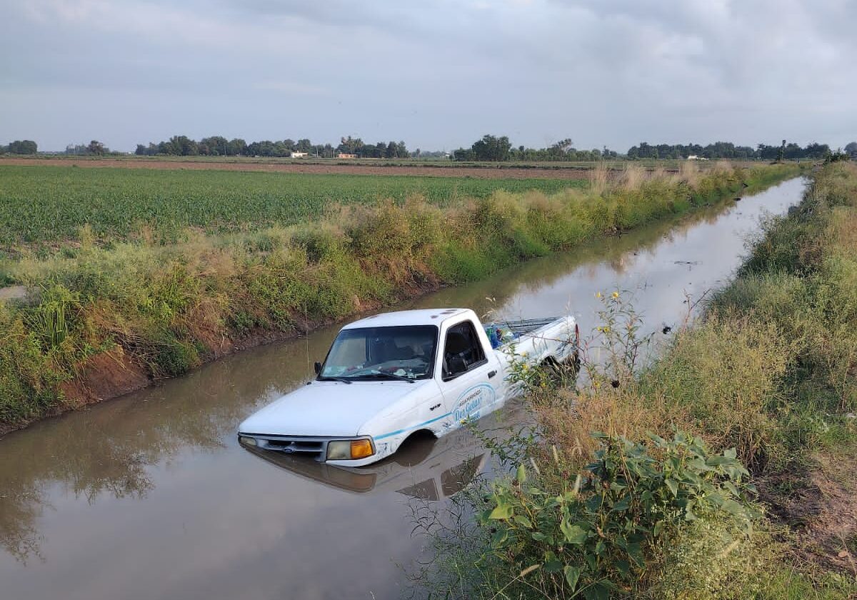 Camioneta Ford blanca en un canal de Guasave