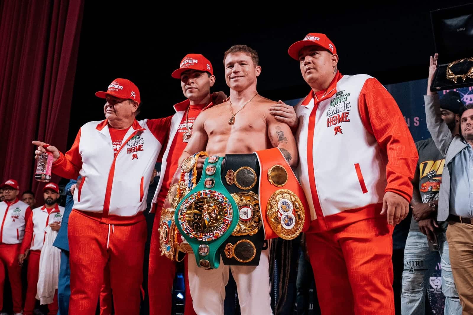 Canelo Álvarez sosteniendo sus cinturones