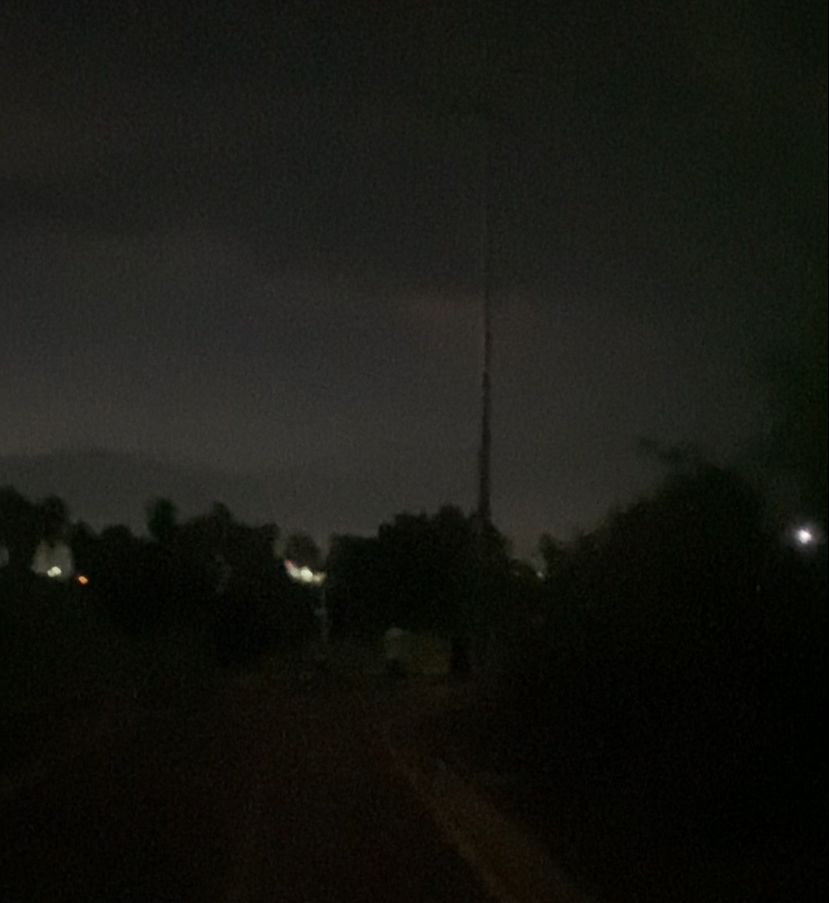 Cerro obscuro con luces al fondo