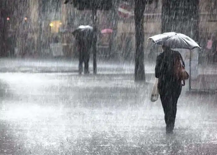 Mujer con sombrilla bajo la lluvia