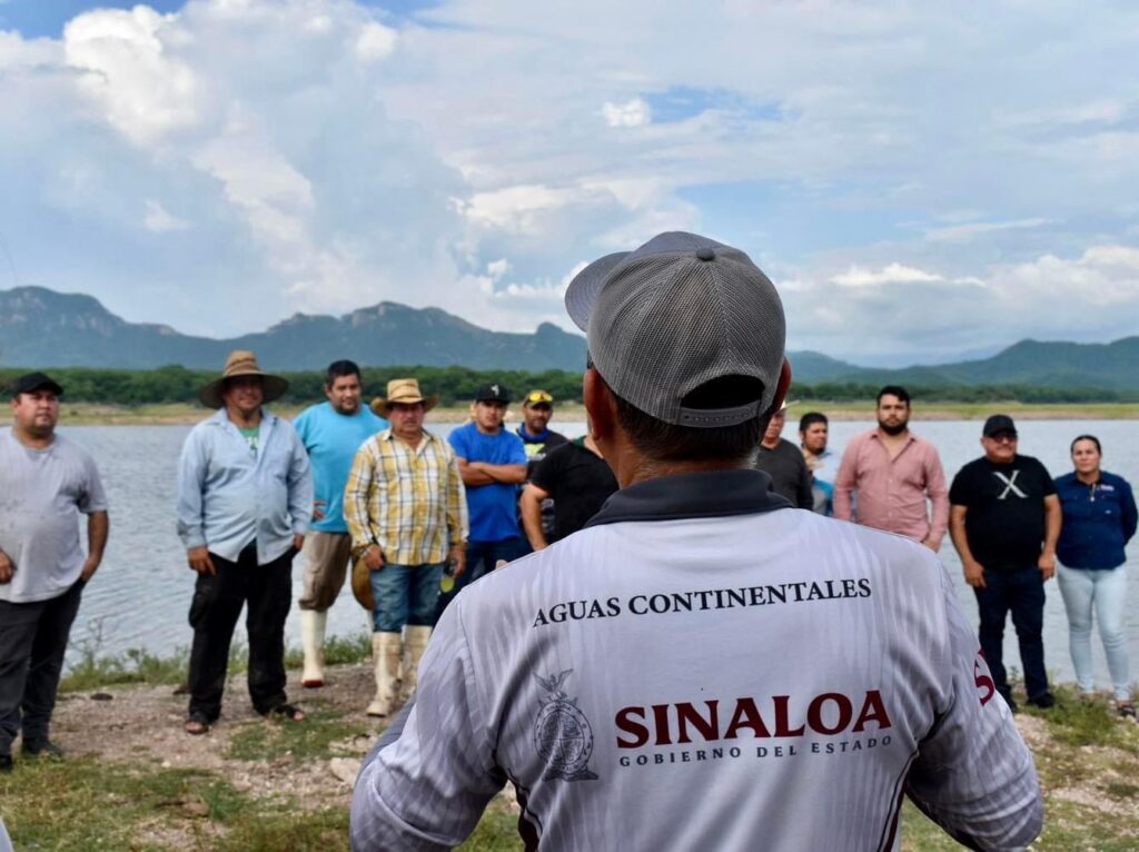 Personas reunidas y al fondo agua de una presa