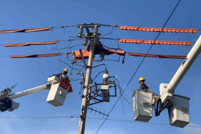 Personal de CFE trabajando en poste de luz