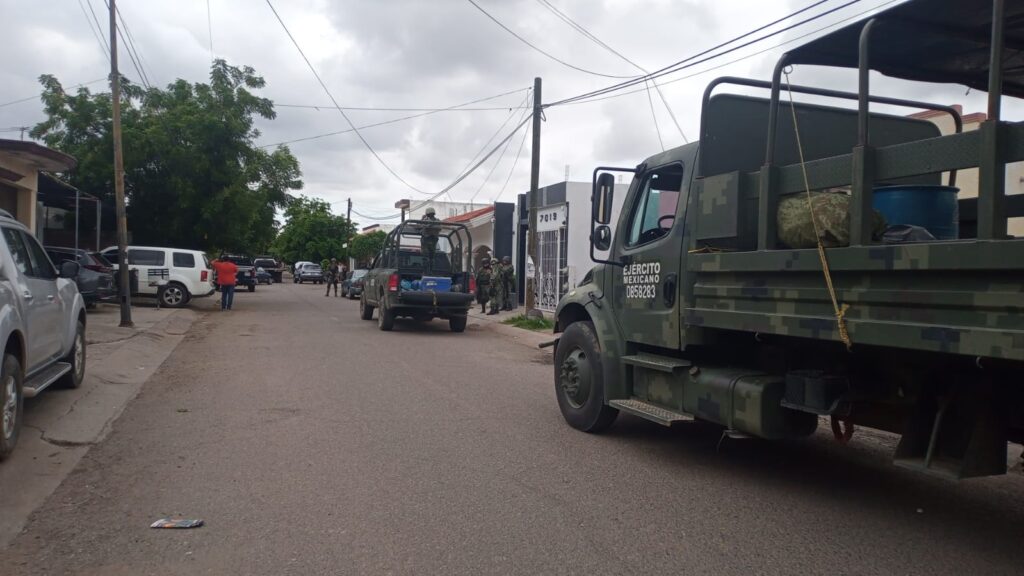 Camión, camioneta y personas con uniforme del Ejército Mexicano
