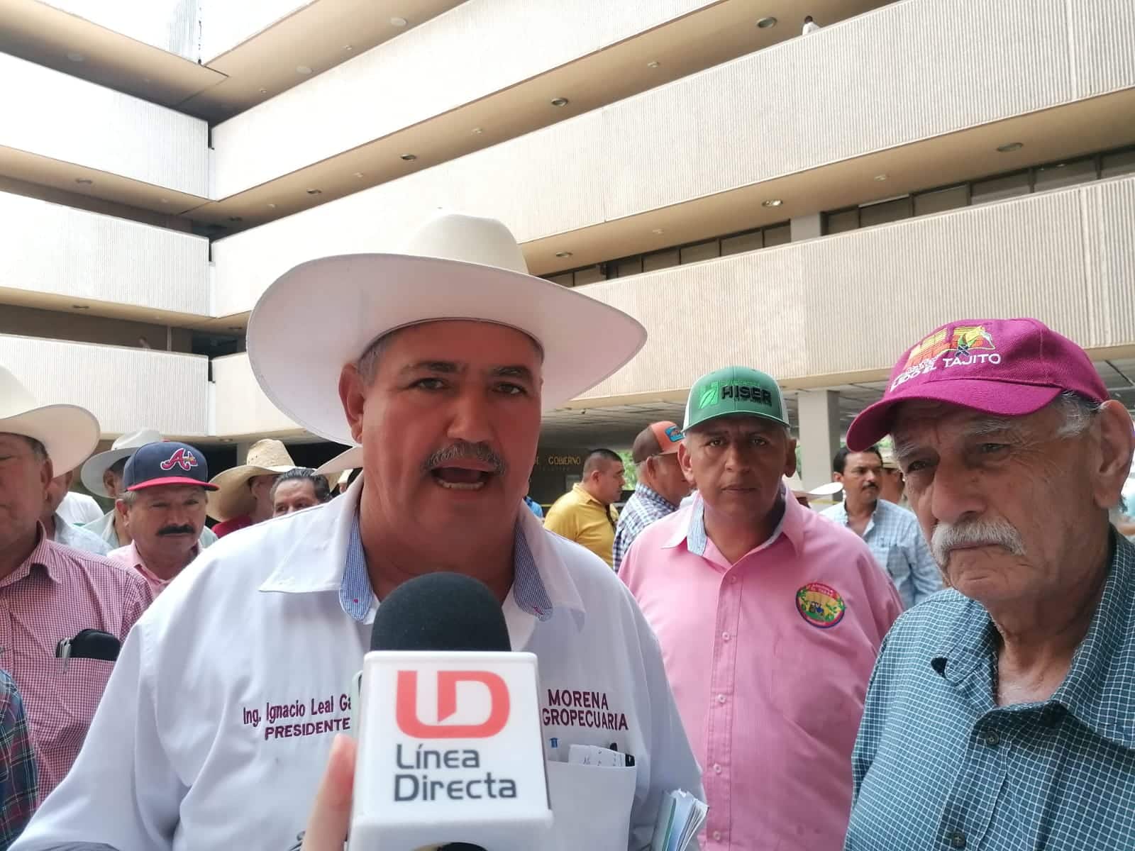 Personas y una de ellas con sombrero hablando y un micrófono de LD