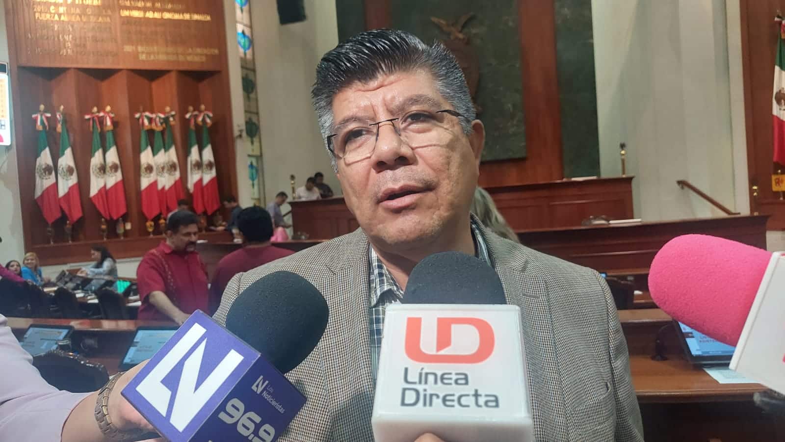 Una persona hablando y micrófonos de medios de comunicación