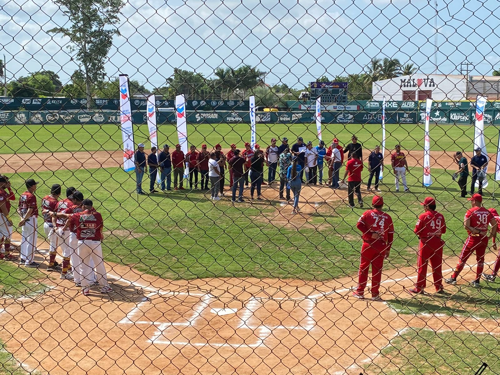 Personas paradas en una cancha de beisbol