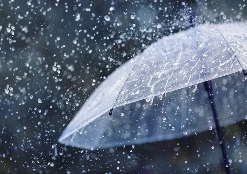 Un paraguas cayéndole gotas de agua de la lluvia