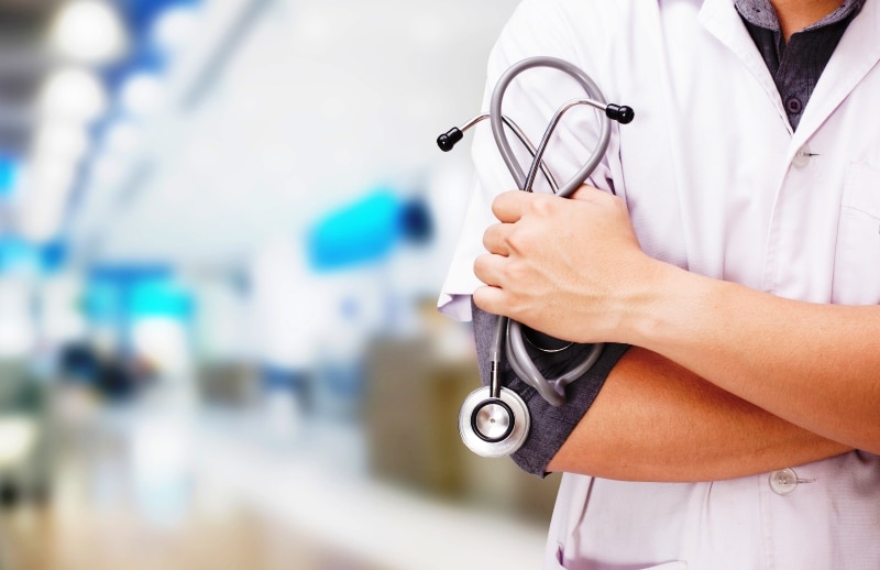Doctor with a stethoscope in the hands and hospital background