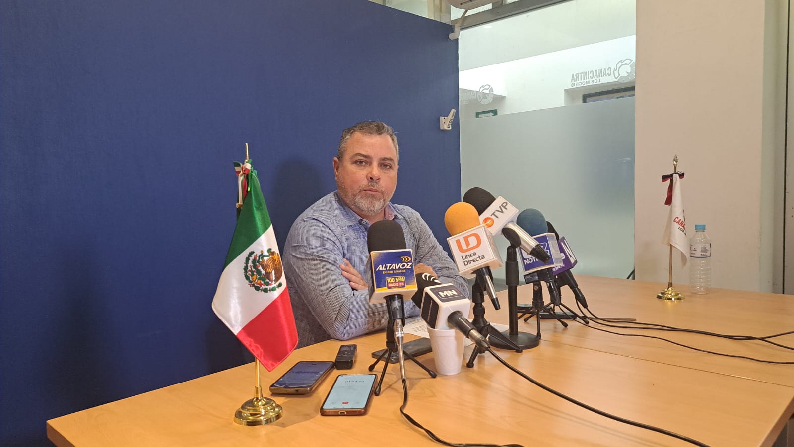 Una persona sentada y micrófonos de los medios de comunicación