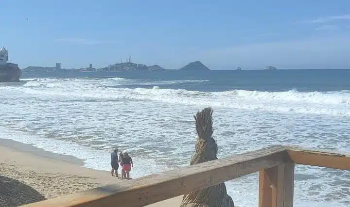 Personas en la orilla de la playa de Mazatlán y olas