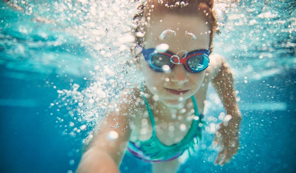 Un niño con googles en una alberca