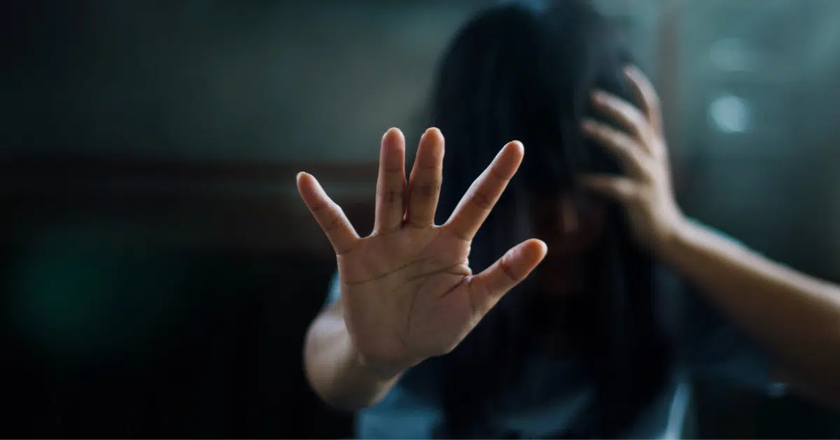 Mujer con la mano extendida hacia enfrente mientras toca su cabeza