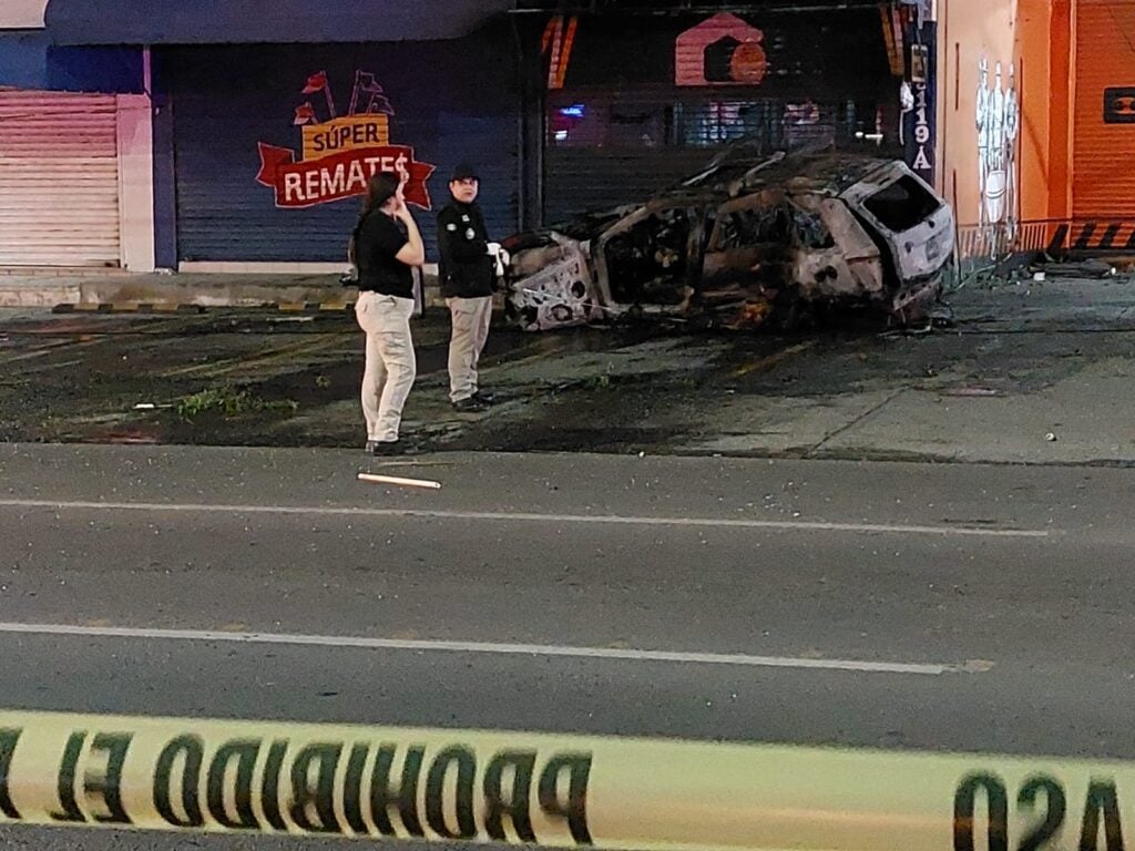 Peritos trabajan en la escena con una camioneta Grand Cherokee calcinada tras choque en Culiacán