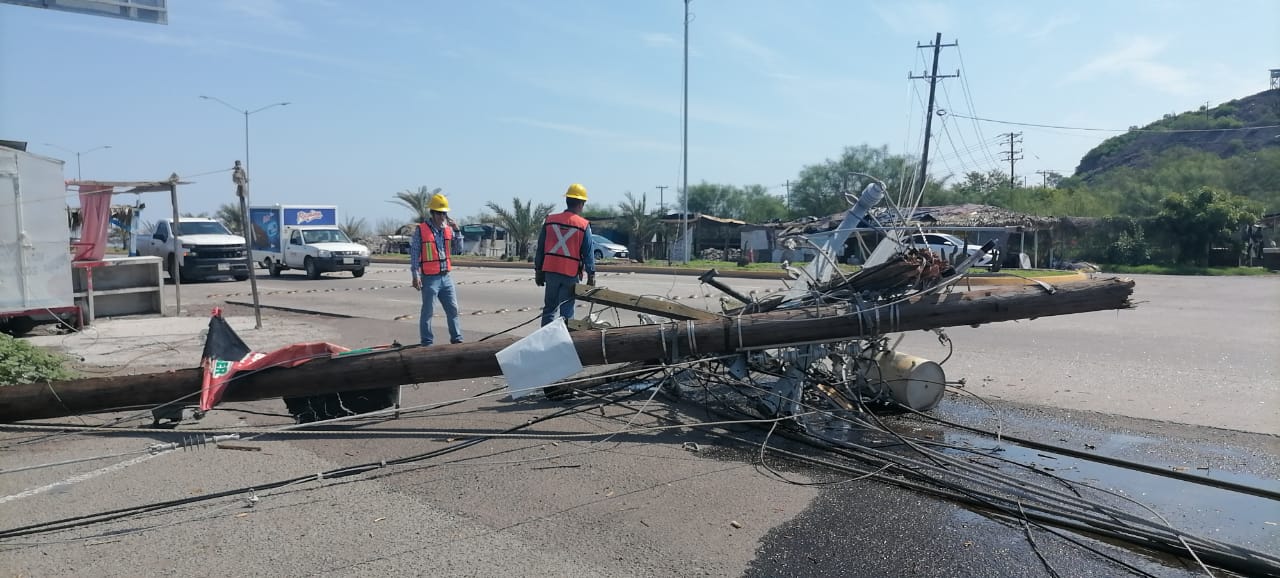 Poste de la CFE en el suelo, cables y personas