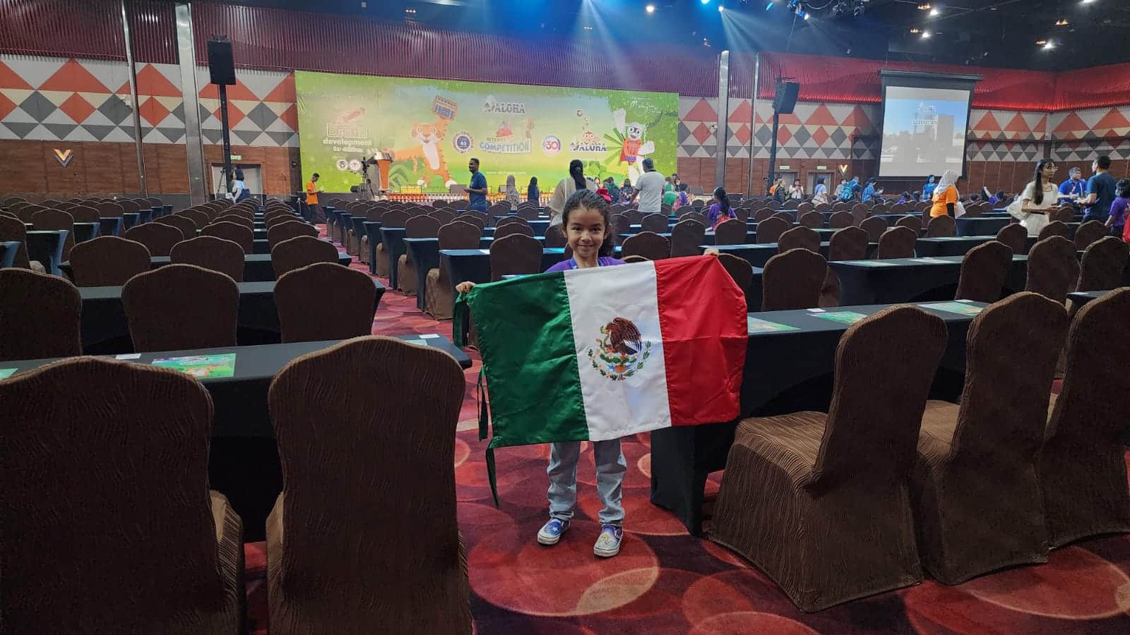 Regina Rass muestra la bandera de México durante el l Campeonato Mundial de Cálculo Aloha 2023