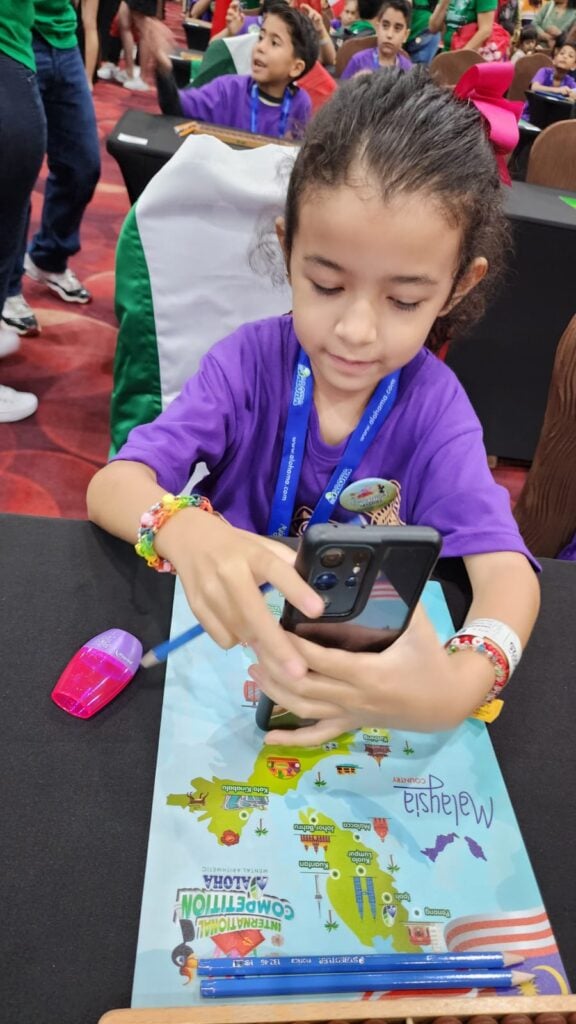 Regina Rass sostiene un teléfono celular durante campeonato en Malasia