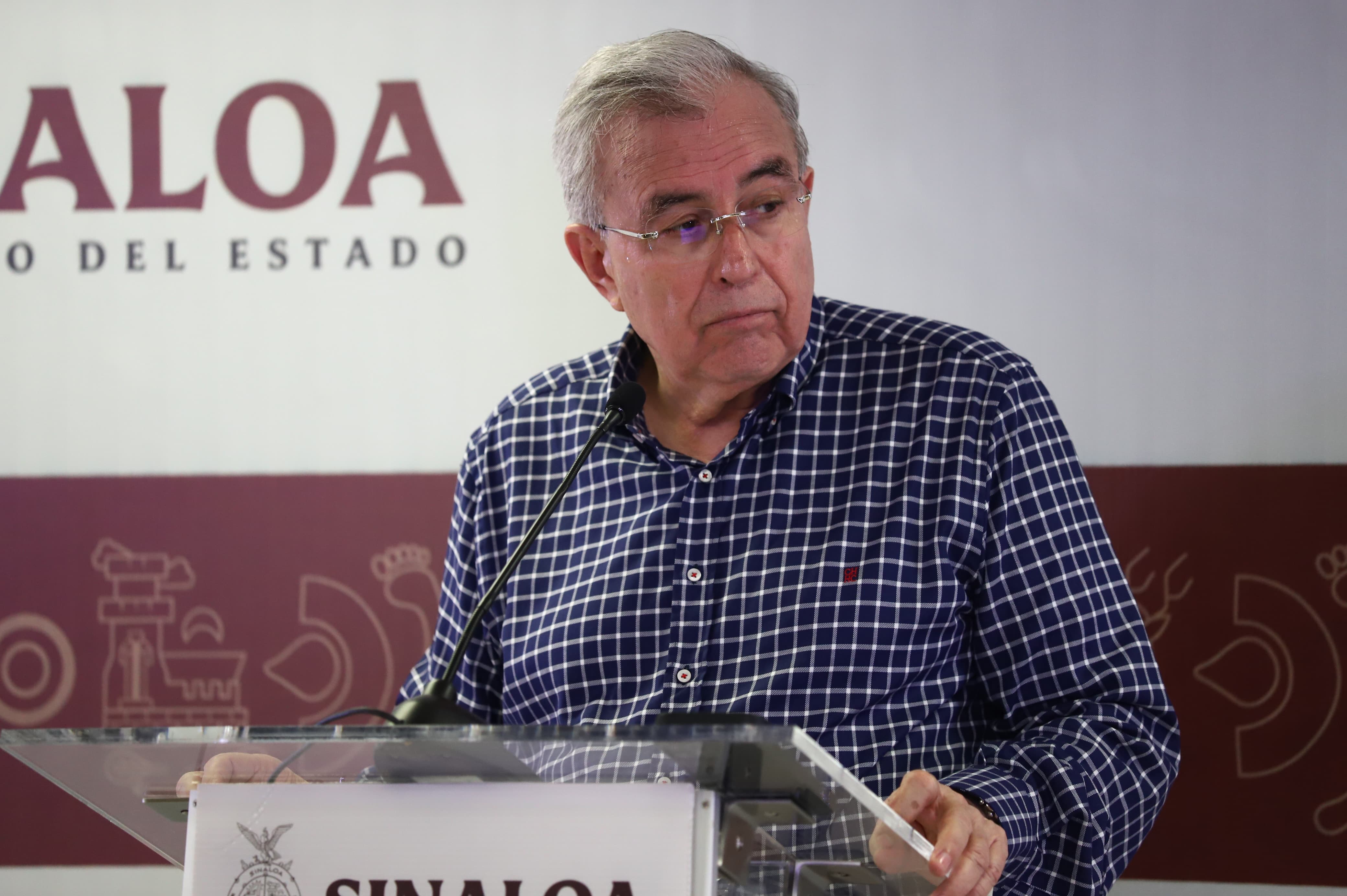 Una persona con letes, un podium y un micrófono