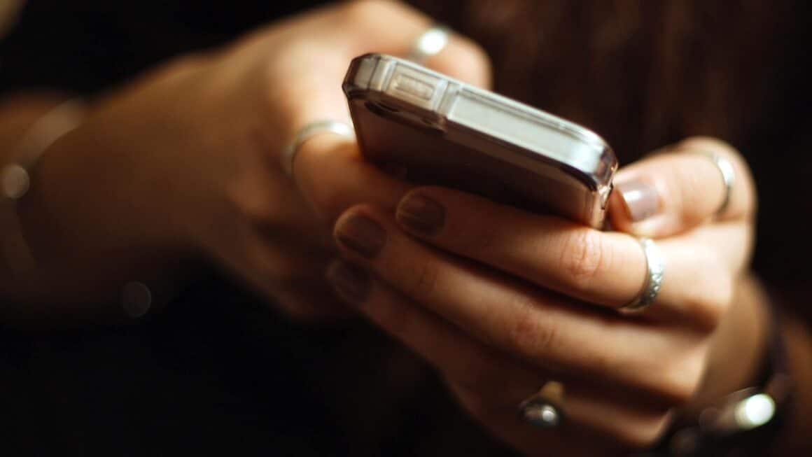 Manos sosteniendo un teléfono celular