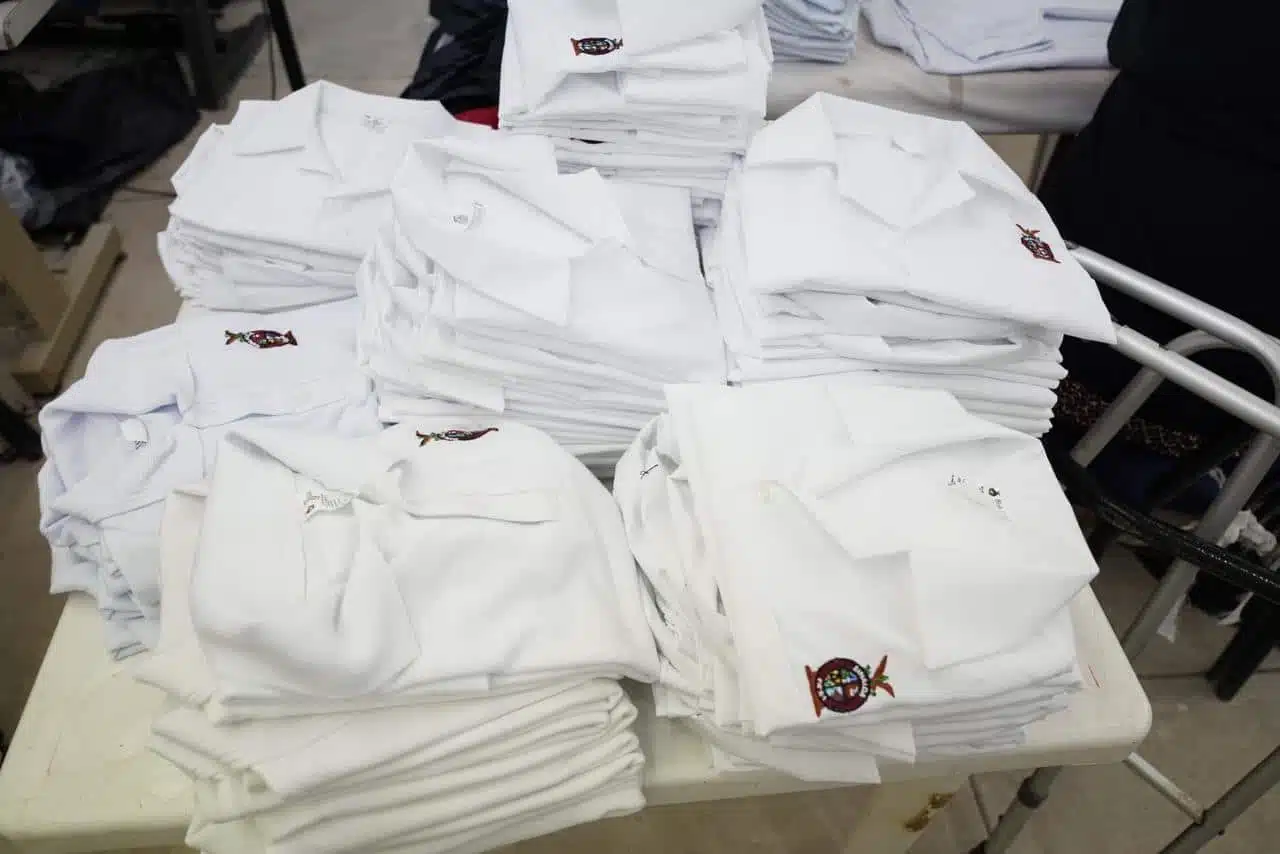 Muchos uniformes escolares gratuitos apilados en una mesa