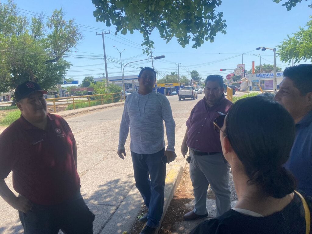 Personas platicando bajo la sombra de un árbol