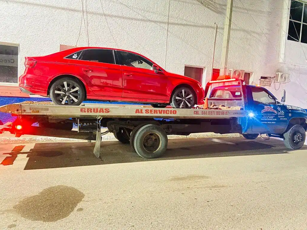 Audi, tipo A3 color rojo, modelo 2017 sobre tráiler