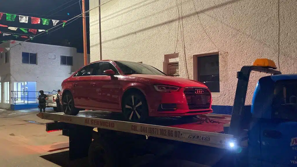 Audi, tipo A3 color rojo, modelo 2017 sobre tráiler