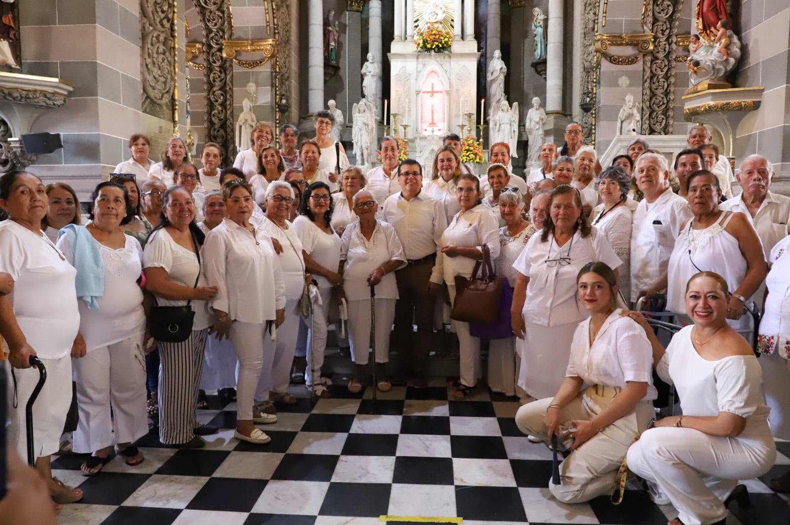 Personas de blanco paradas dentro de una iglesia