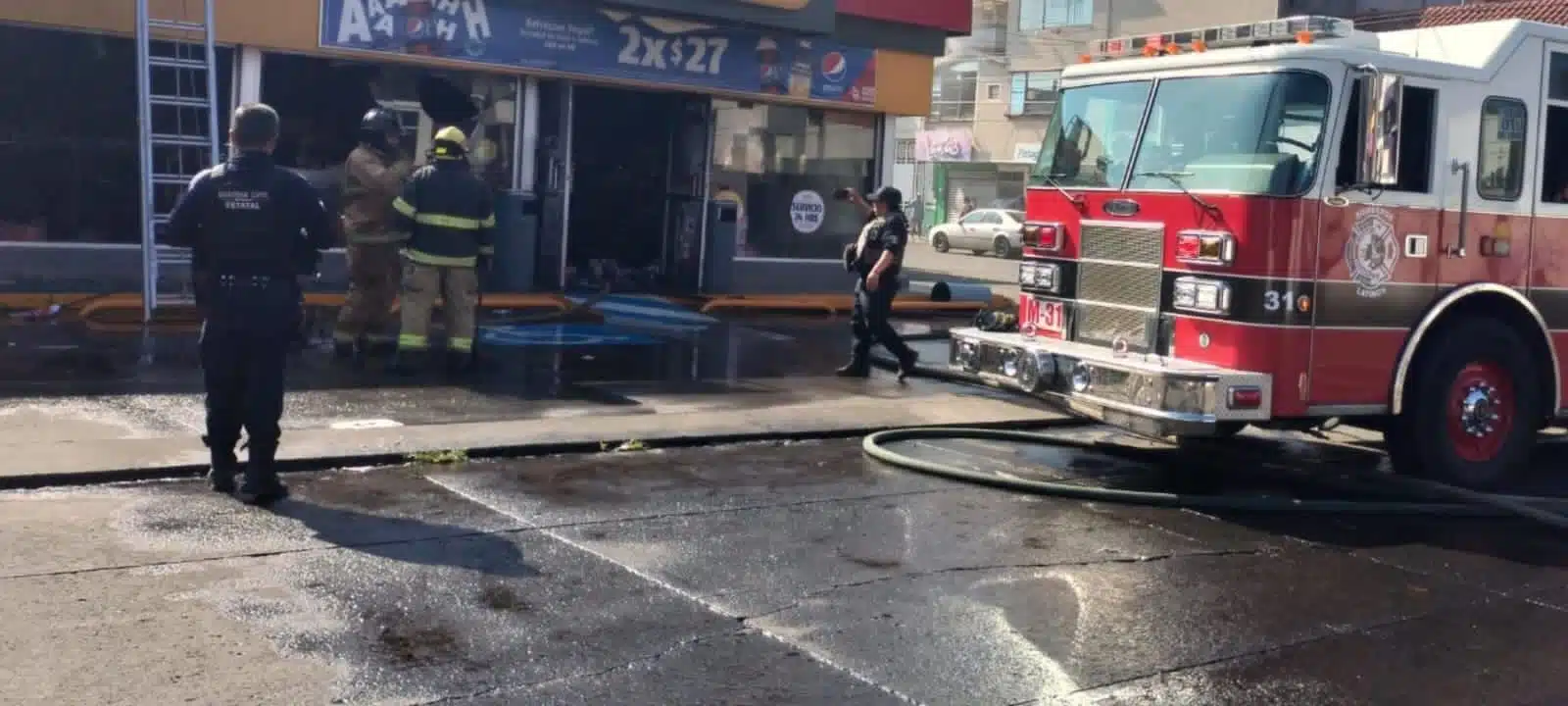 Bomberos sofocando las llamas en tienda de conveniencia