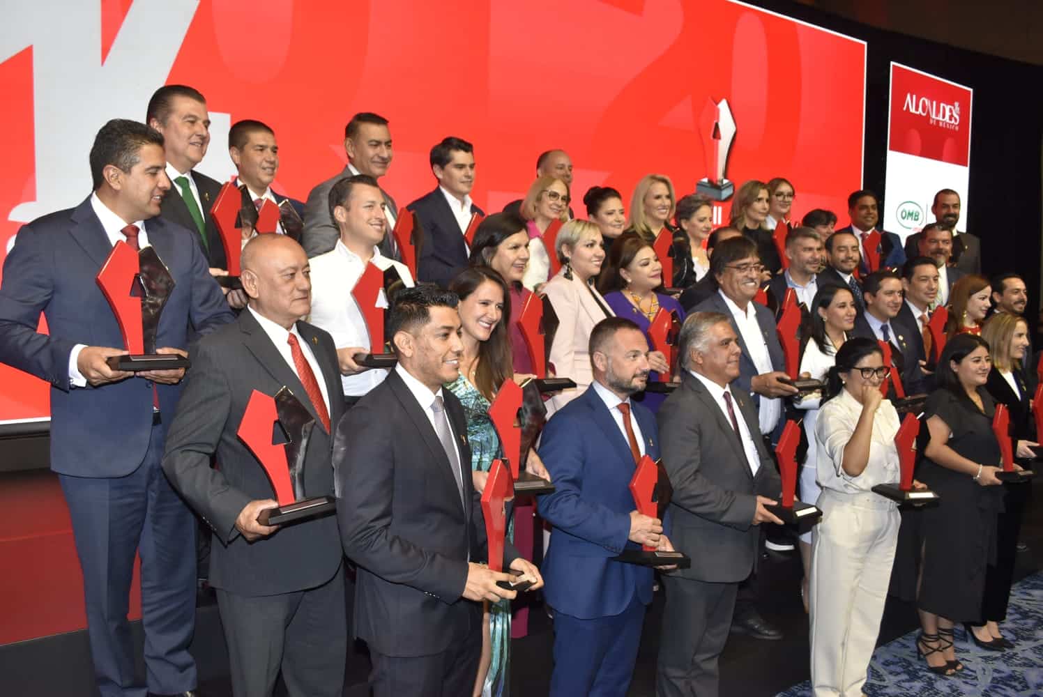 Personas con reconocimiento en la mano y posando para una foto