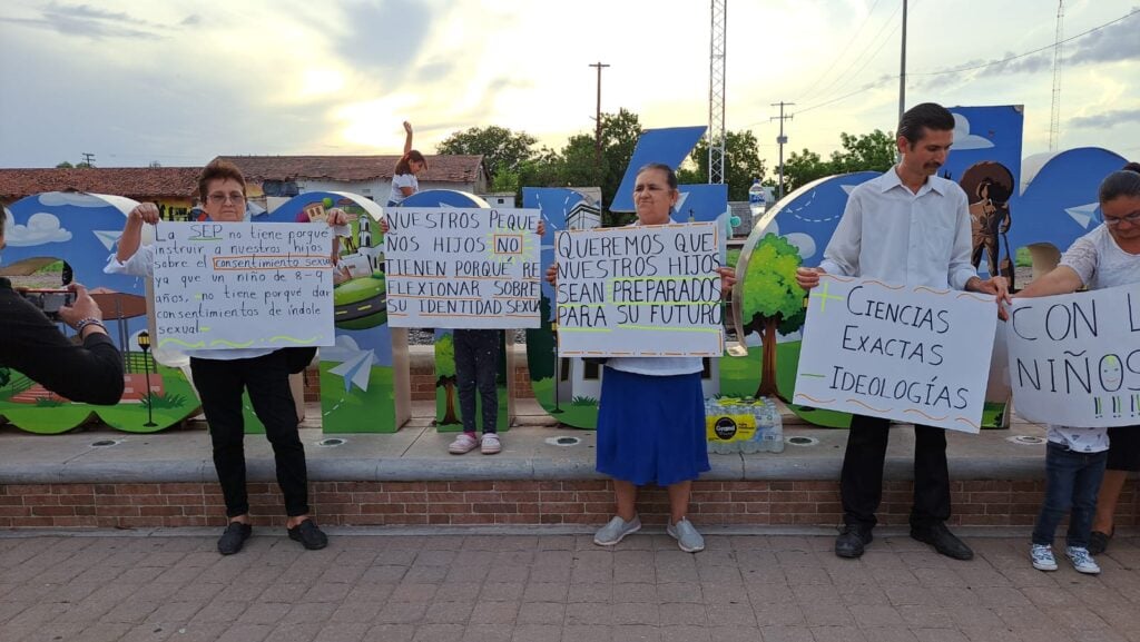 Padres de familia con cartulinas en manifestación en contra de contenidos sexual de los libros de texto