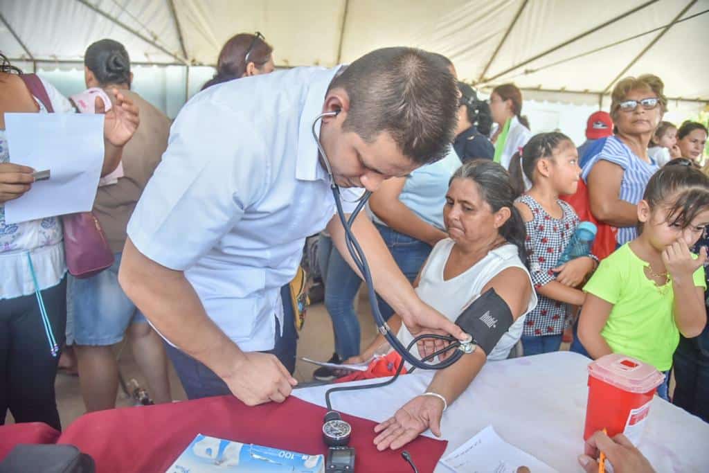 Especialista revisando la presión de una mujer