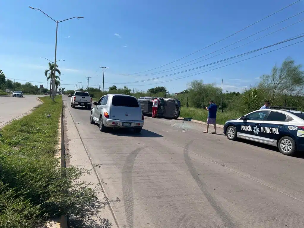 Tránsito frente a una camioneta volcada mientras autos transitan por el lugar