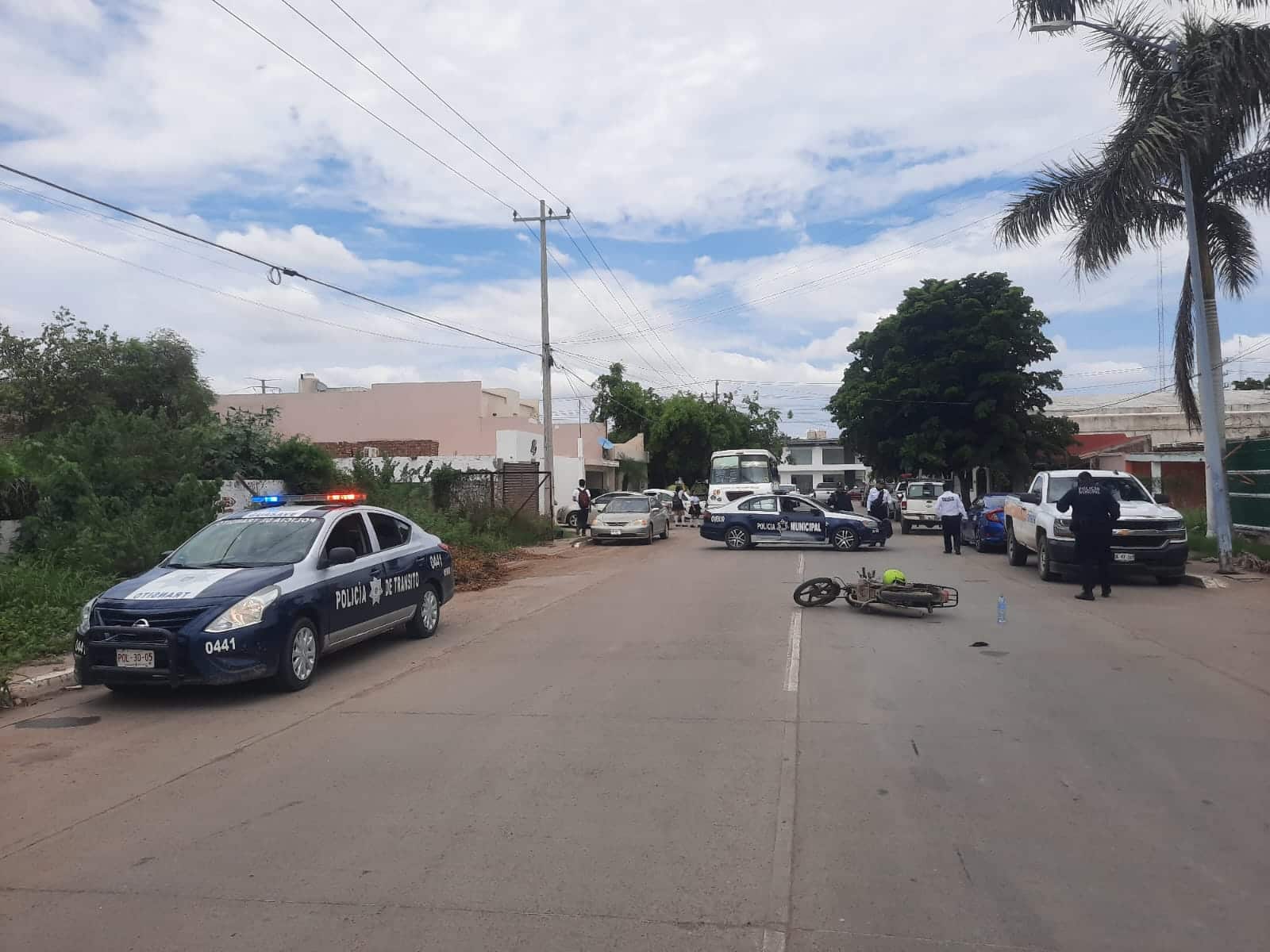motocicleta a media carretera y a lo lejos elementos policiacos y carros.