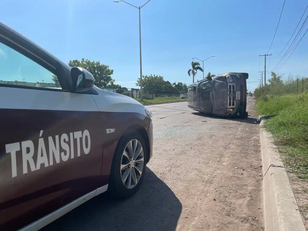 Vehículo de tránsito frente a una camioneta volcada sobre su costado derecho