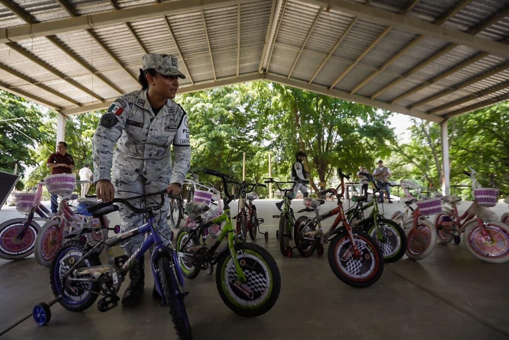 Miembro de Guardia Nacional con bicicletas para niños