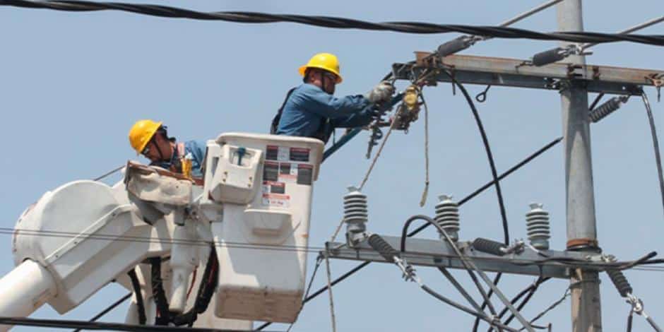 Personal de CFE trabajando en poste de luz