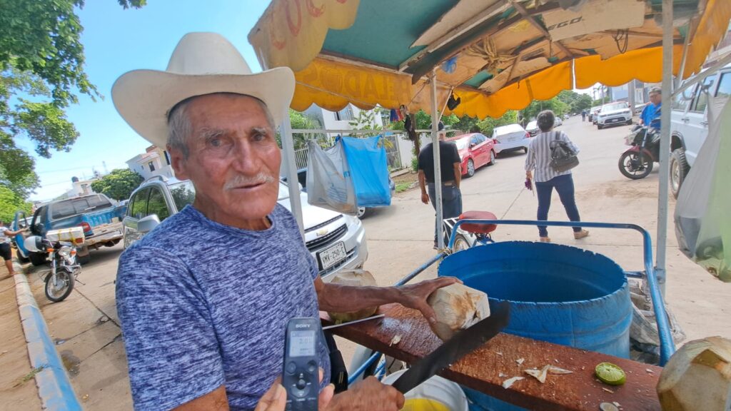 Don José Apodaca Gastélum pelando cocos en su triciclo