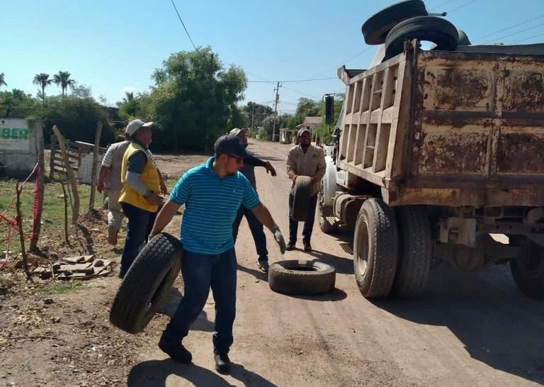 Personas cargando llantas a camión