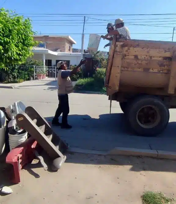 Personas cargando llantas a camión