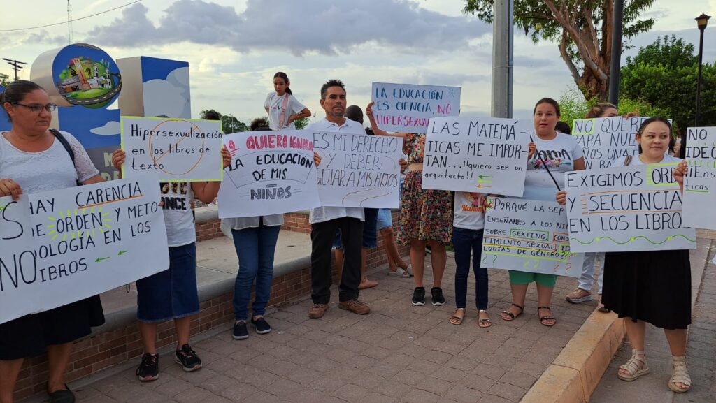 Padres de familia con cartulinas en manifestación en contra de contenidos sexual de los libros de texto