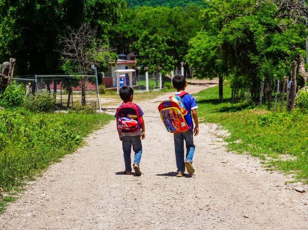 Niños caminando con su mochila puesta.