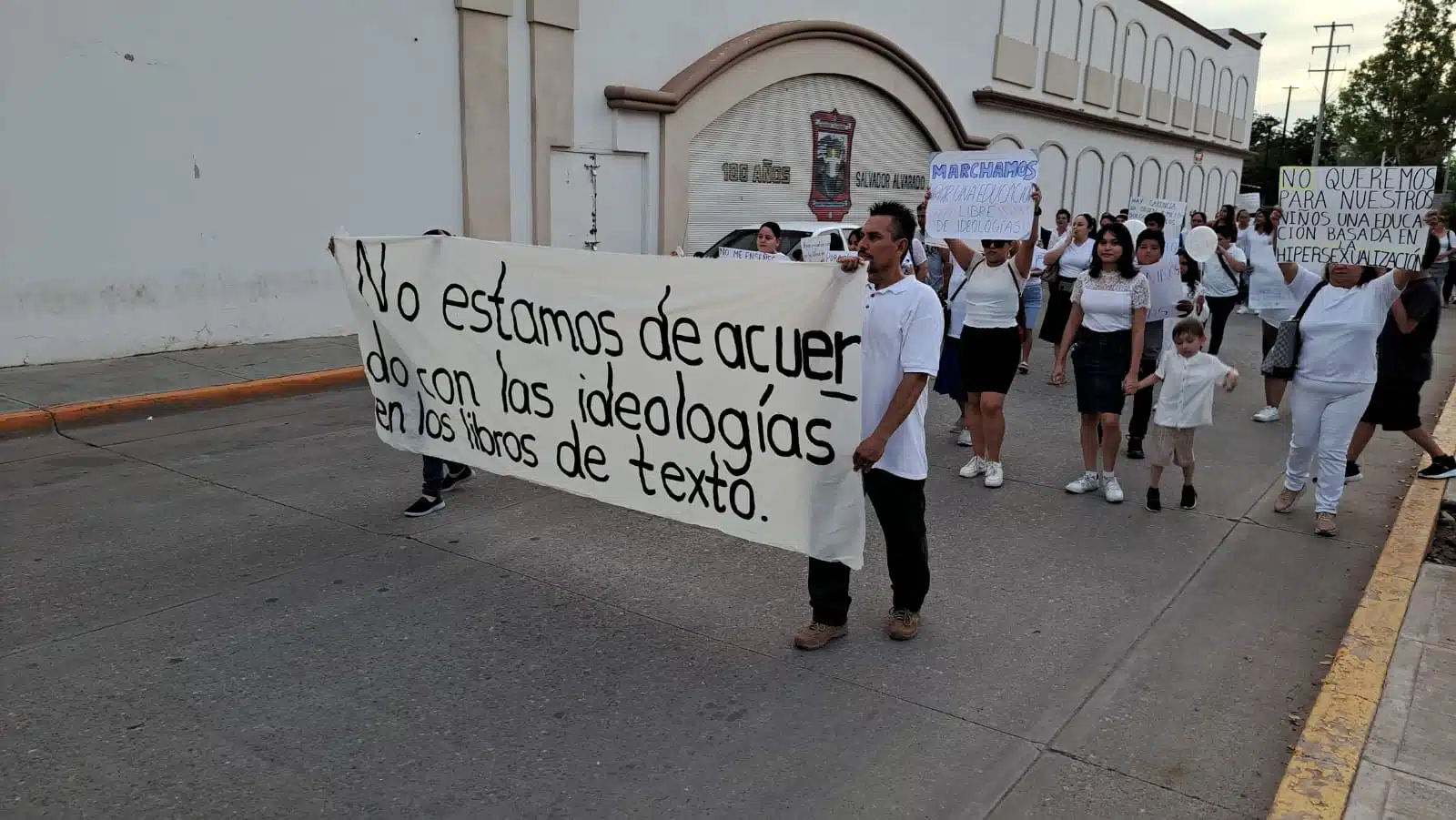 Padres de familia con cartulinas en manifestación en contra de contenidos sexual de los libros de texto