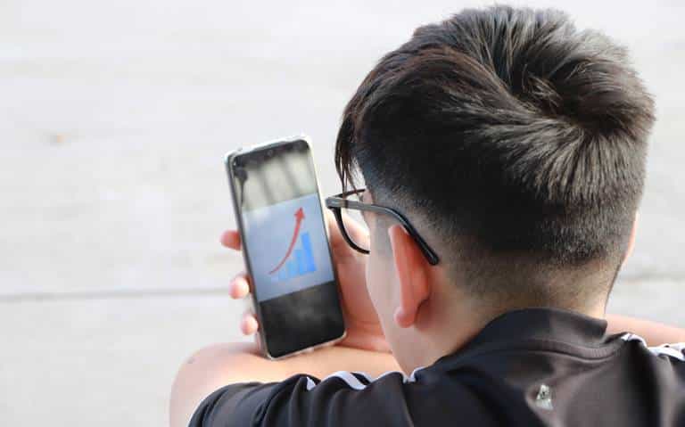 Joven viendo su celular con una flecha