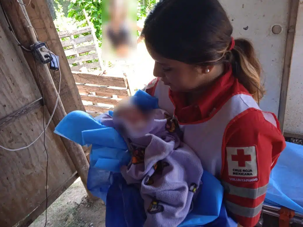 Bebé en brazos de una socorrista de Cruz Roja