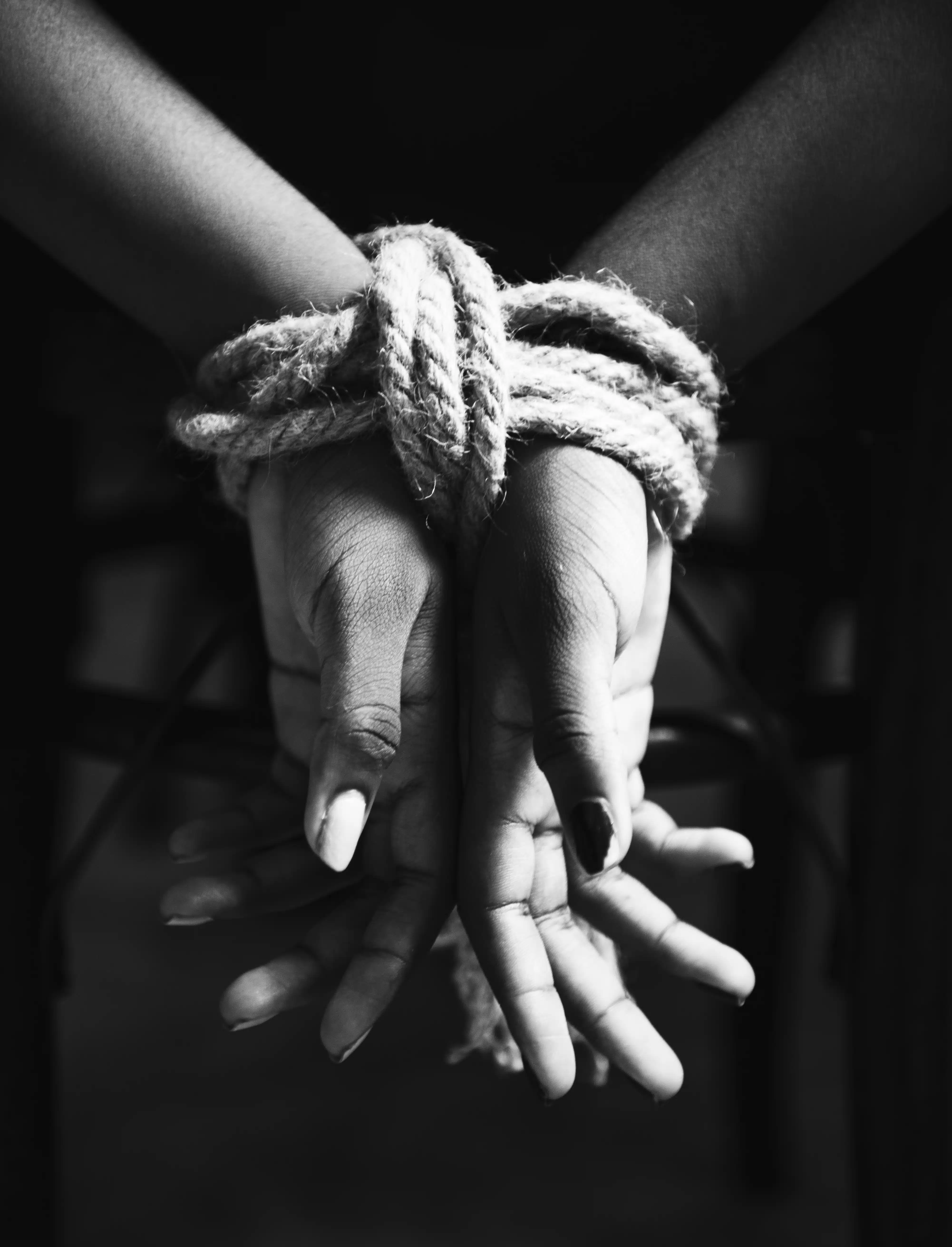 Manos atadas con una cuerda representando violencia y trata de personas