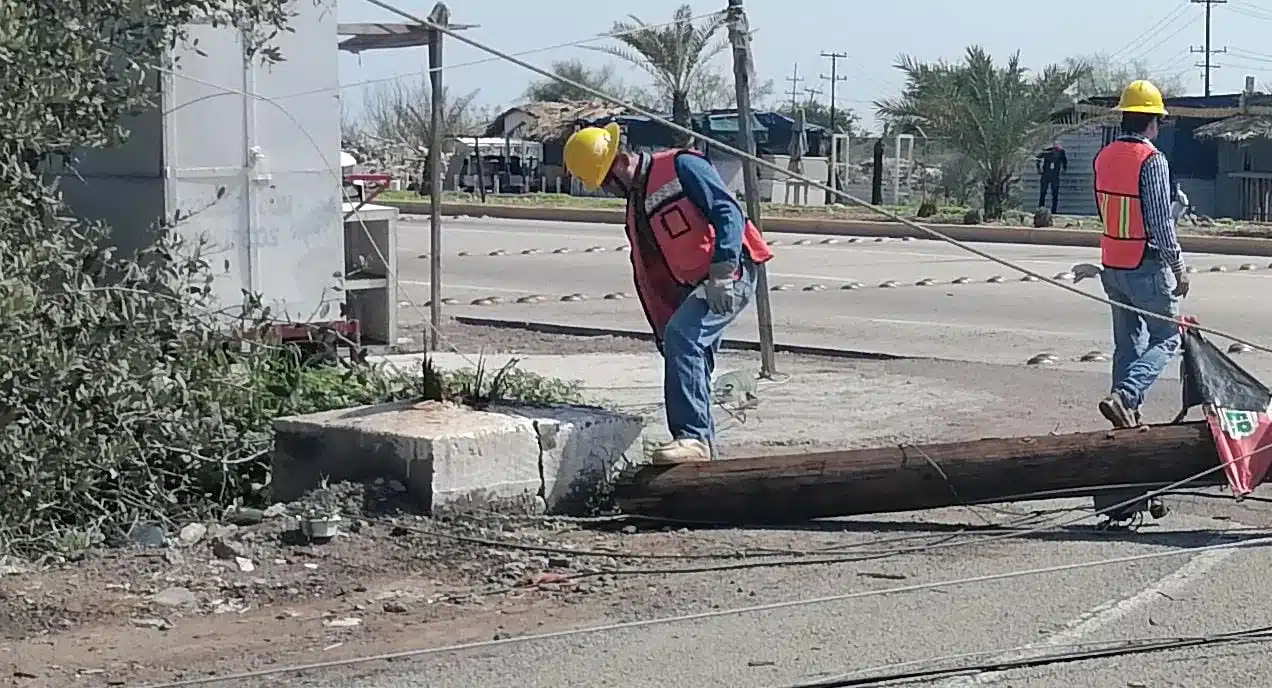 Poste de CFE caído en Topolobampo, trabajadores mirando escena