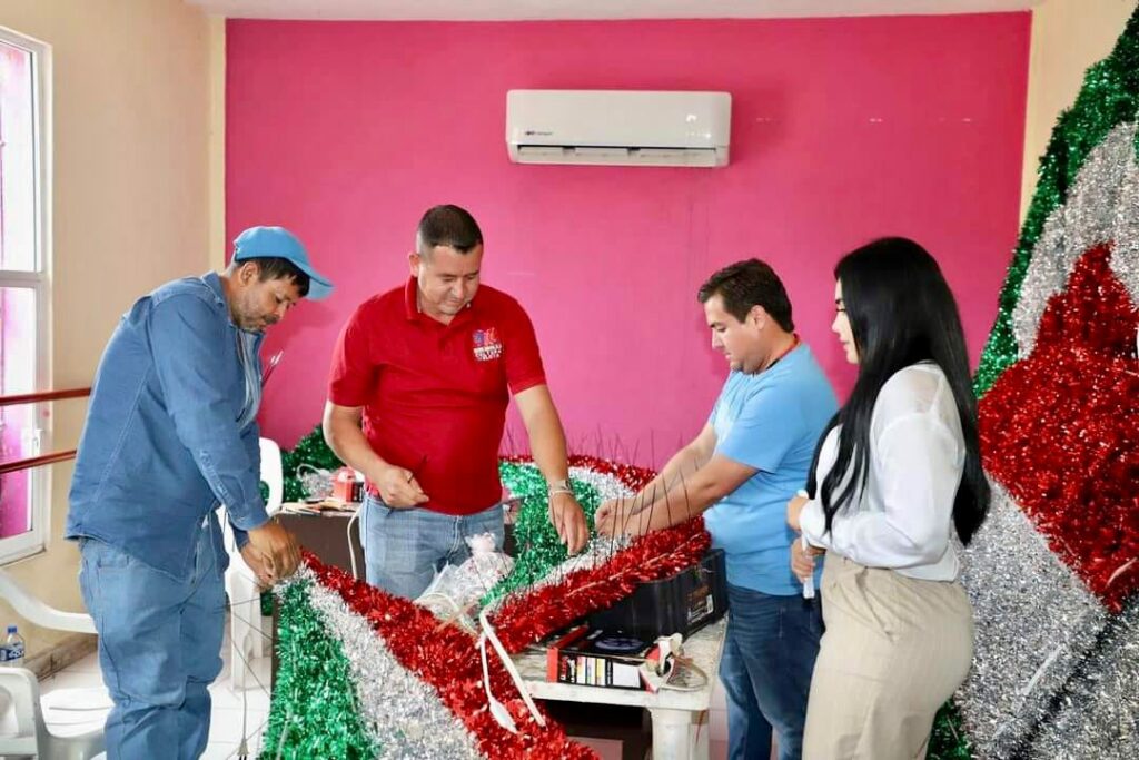 GRUPO DE PERSONAS ALISTANDO DECORACIONES QUE SE PONDRAN EN FESTEJO DEL 16 DE SEPTIEMBRE.