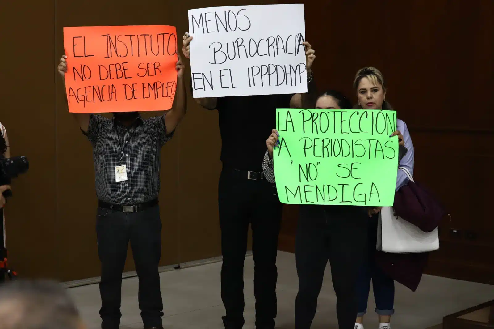Personas manifestándose con cartelones por la protección de periodistas y derechos humanos