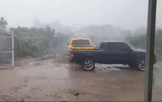Lluvia cayendo sobre la tierra y un par de vehículos en Concordia